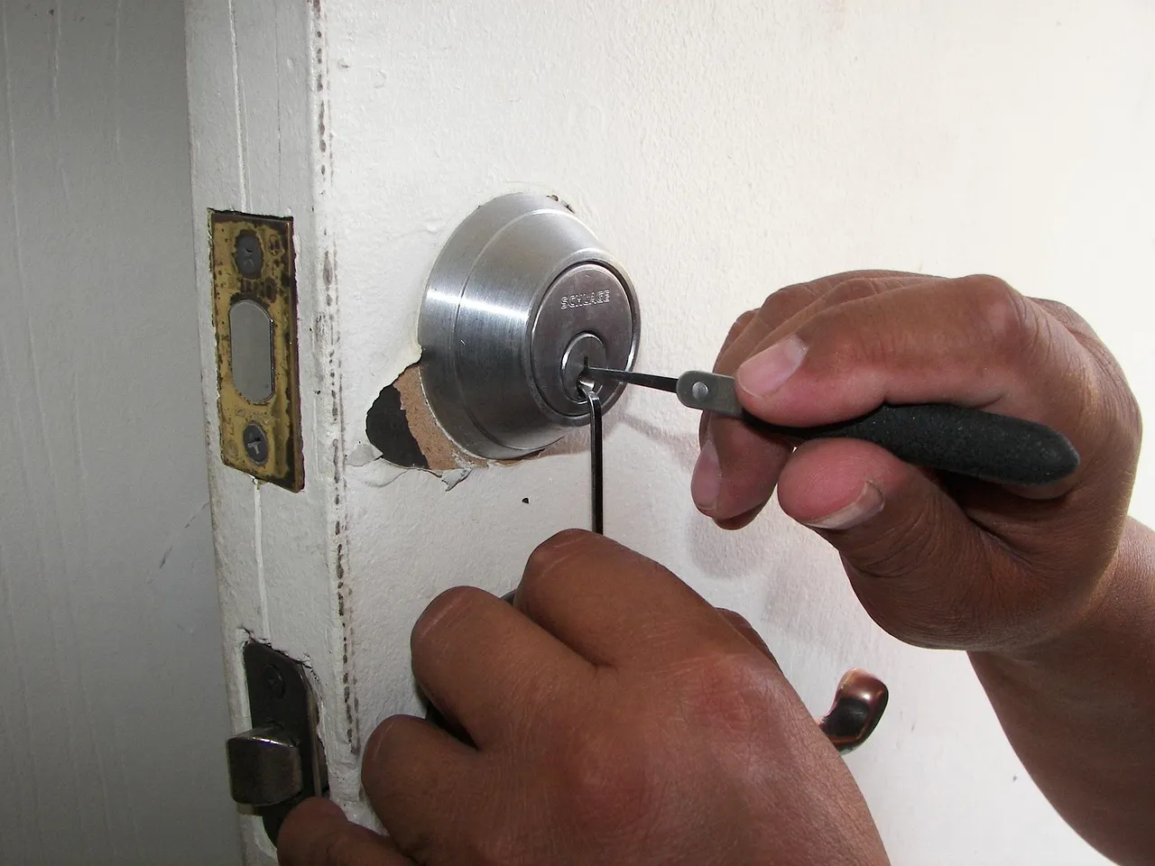 Locksmith picking a residential door lock