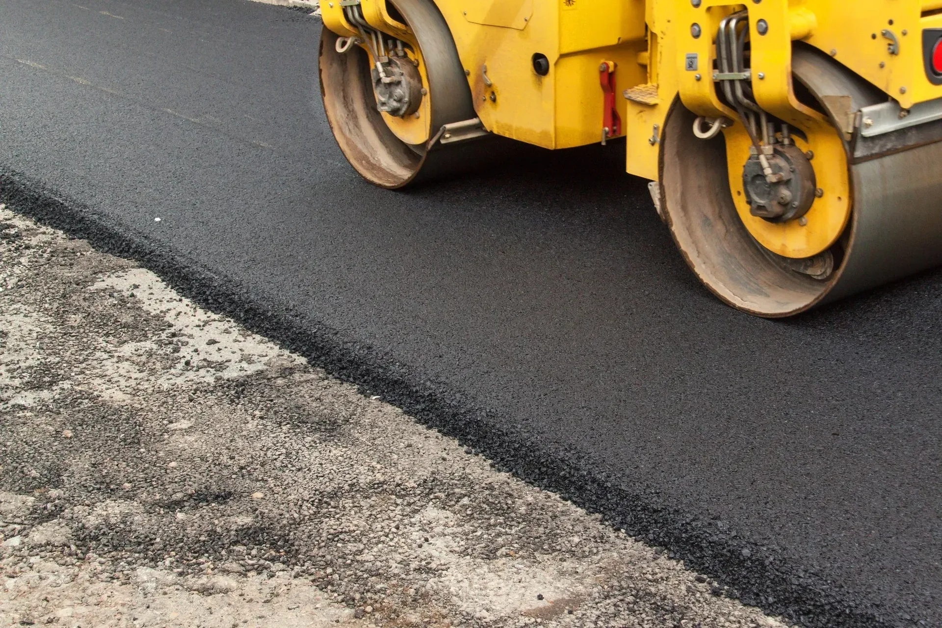 Road roller compacting a freshly laid asphalt surface