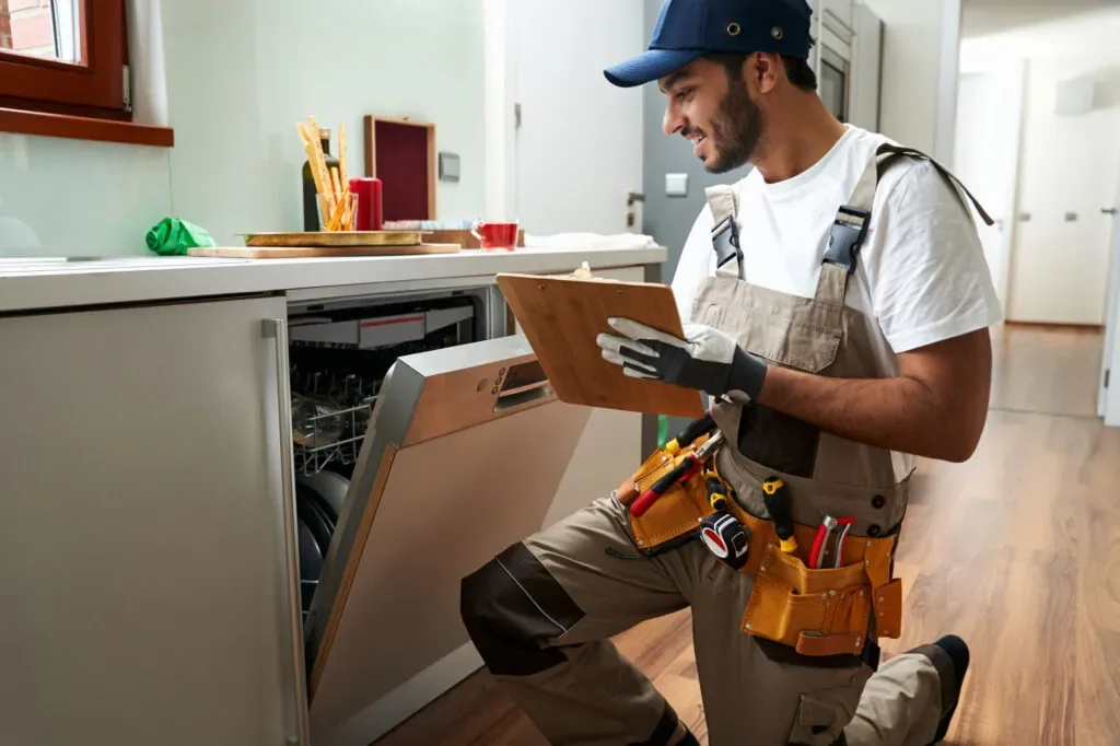 Cabinet installer fitting custom kitchen cabinets with a cordless drill