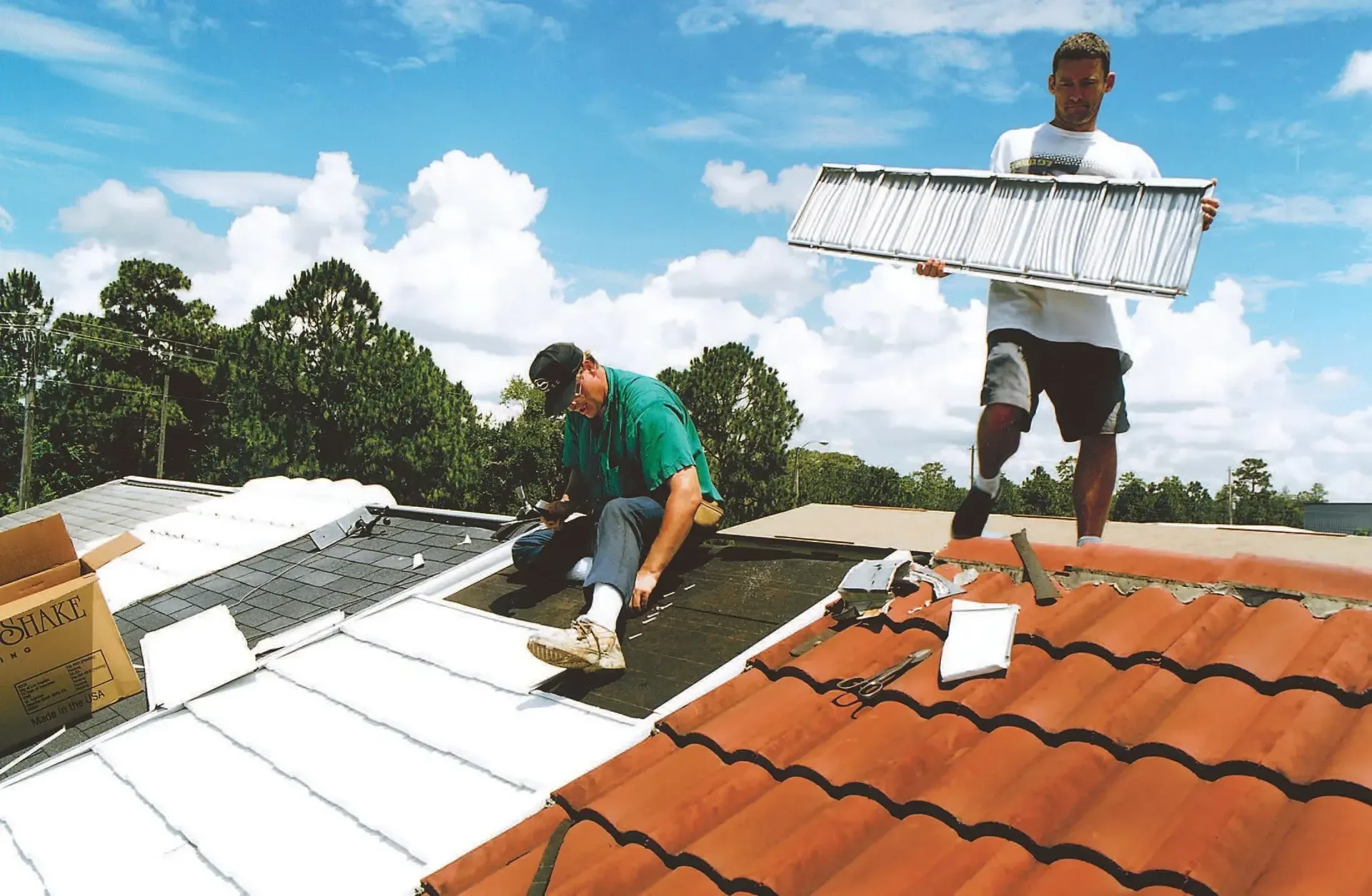 Roofing crew installing tiles across a residential roof