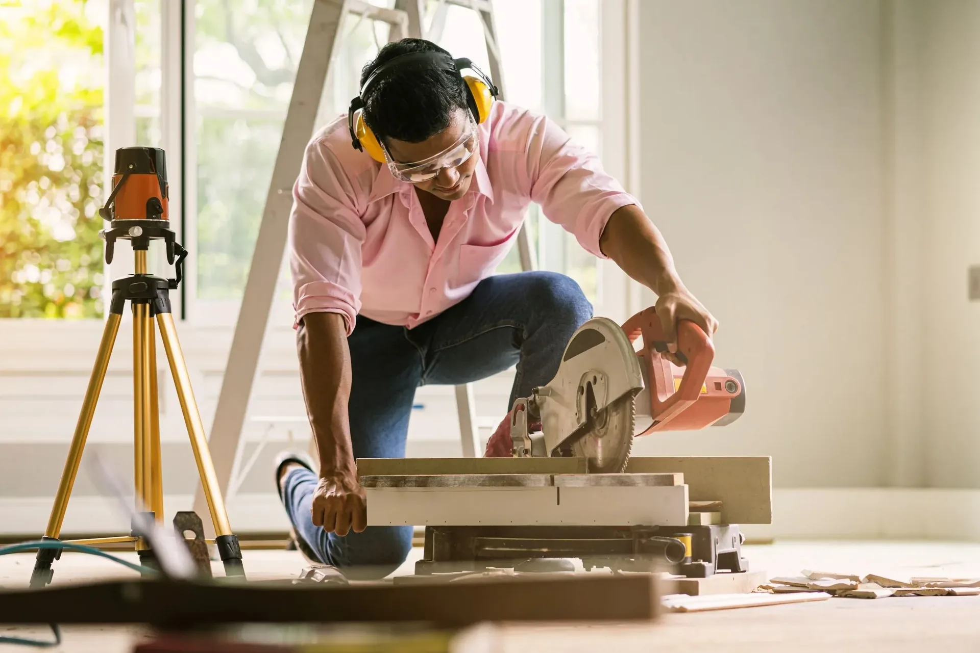 Construction carpenter measuring and cutting timber on site