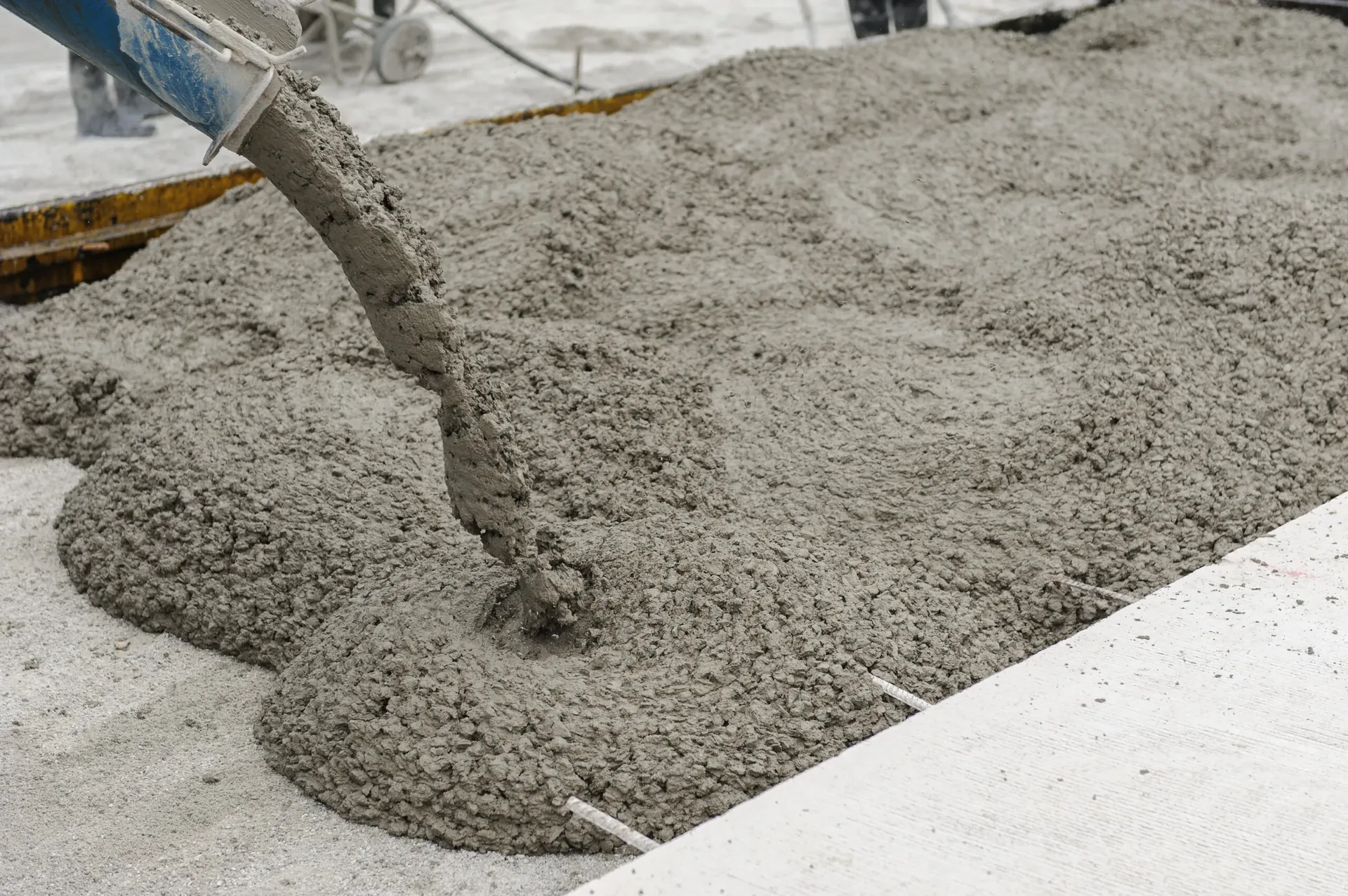 Fresh concrete being poured and spread for a new slab