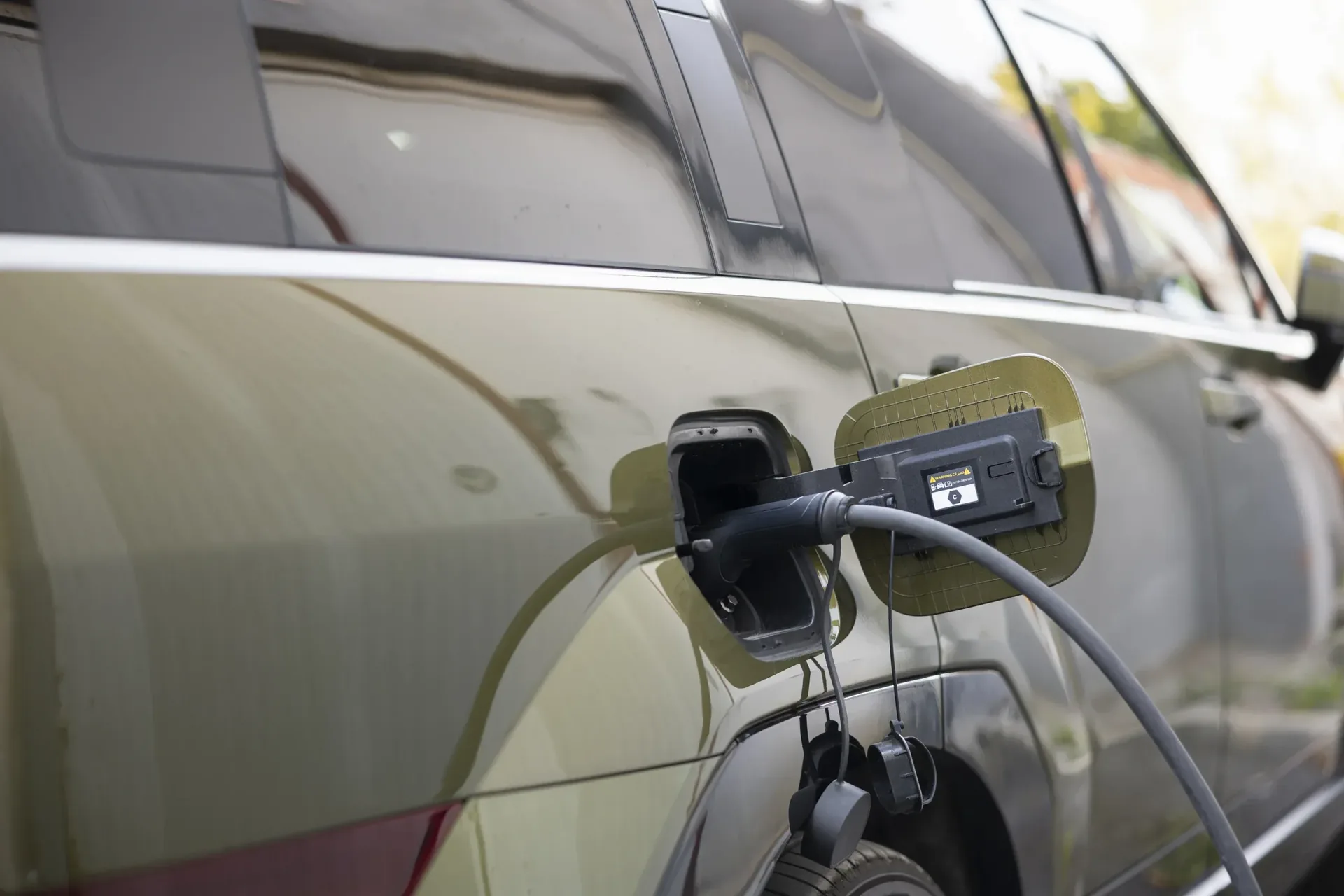 Electric vehicle plugged into a wall mounted home charging station