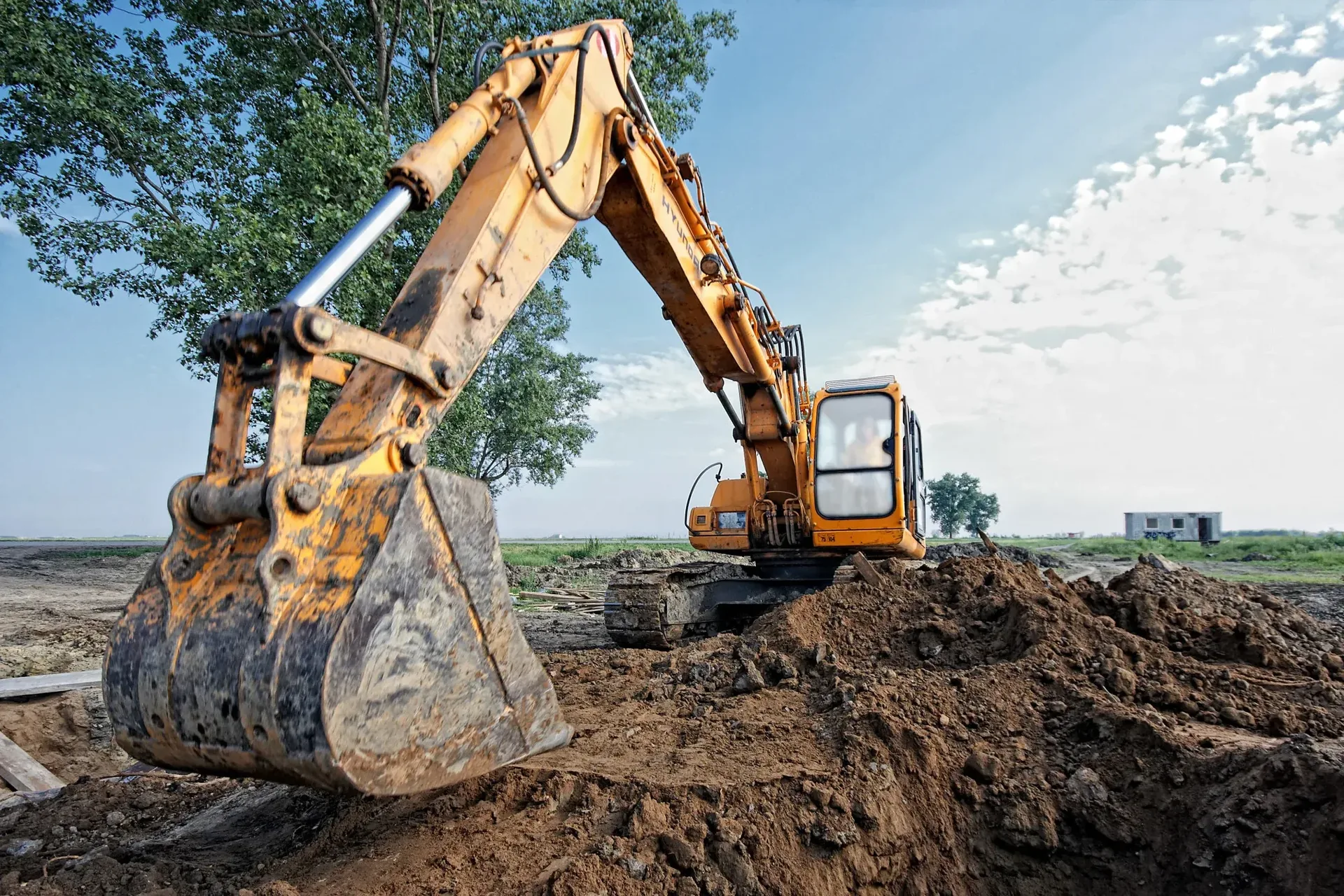 Excavator digging a foundation trench on a cleared lot