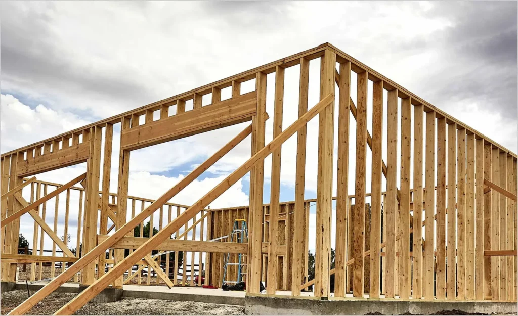 Timber framed house structure standing against an open sky