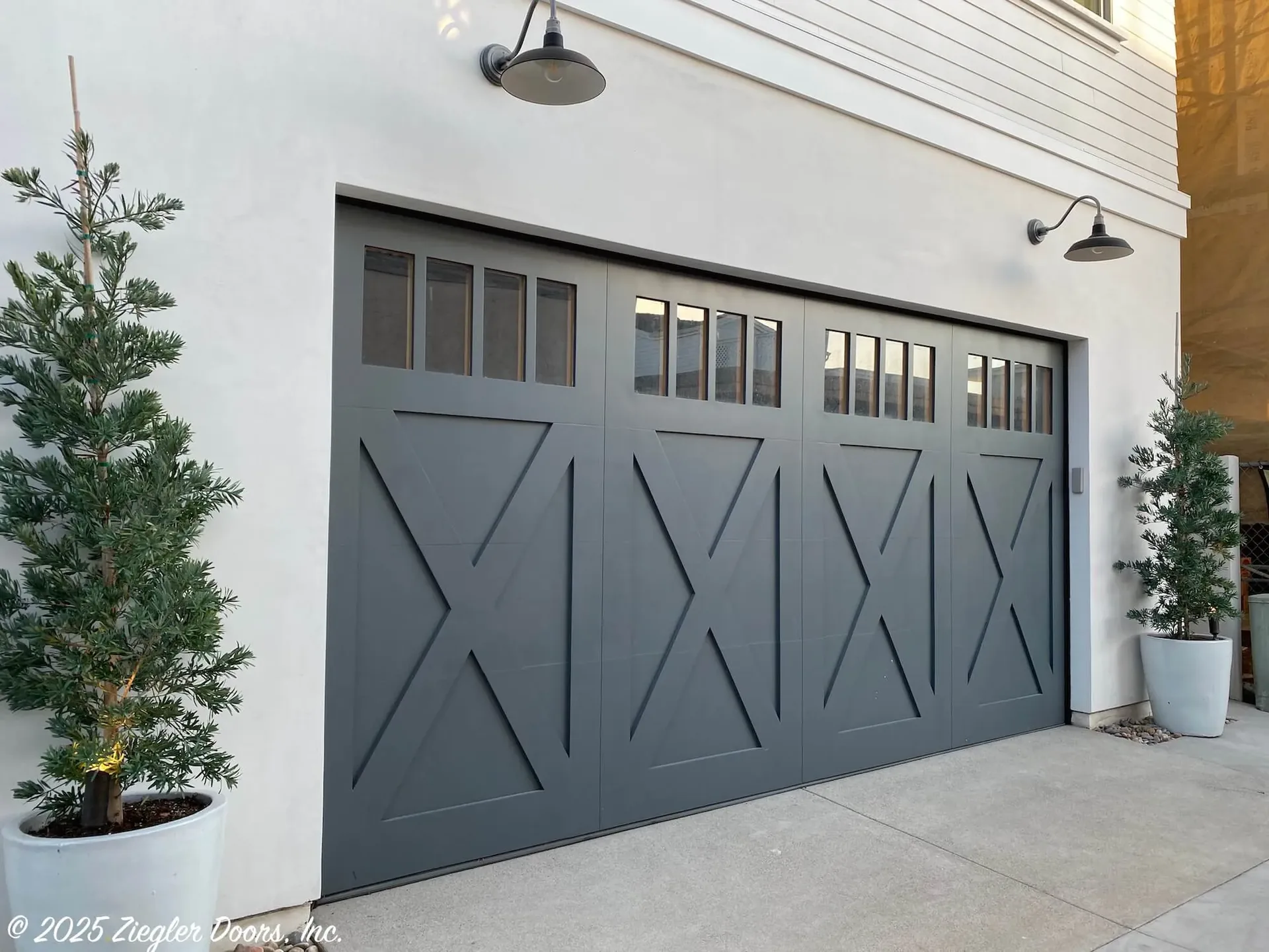 Carriage style garage door on a home with landscaped surroundings