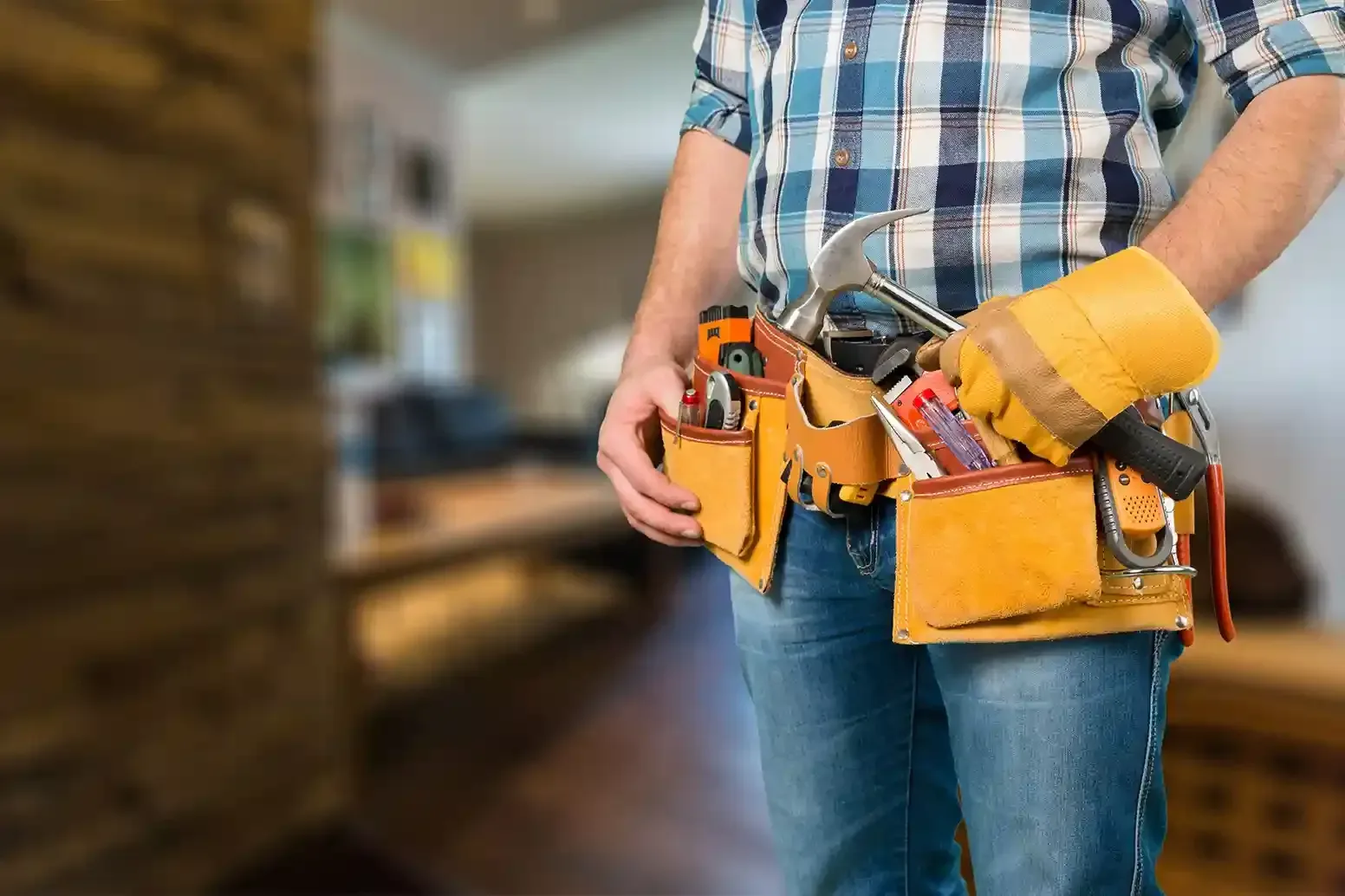 Handyman wearing a leather tool belt filled with hand tools