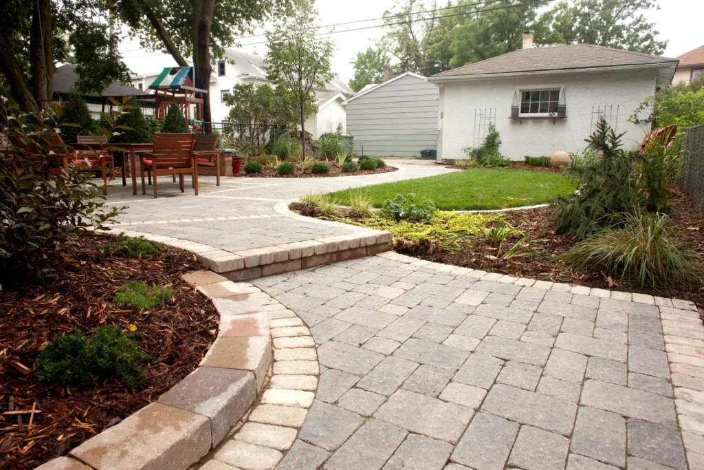 Curved paver walkway and patio in a professionally hardscaped yard
