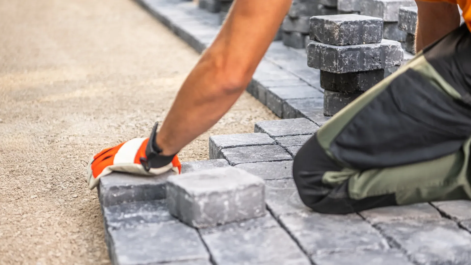 Mason setting and levelling stone pavers with a rubber mallet