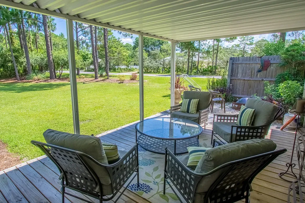 Covered patio with outdoor furniture overlooking a garden