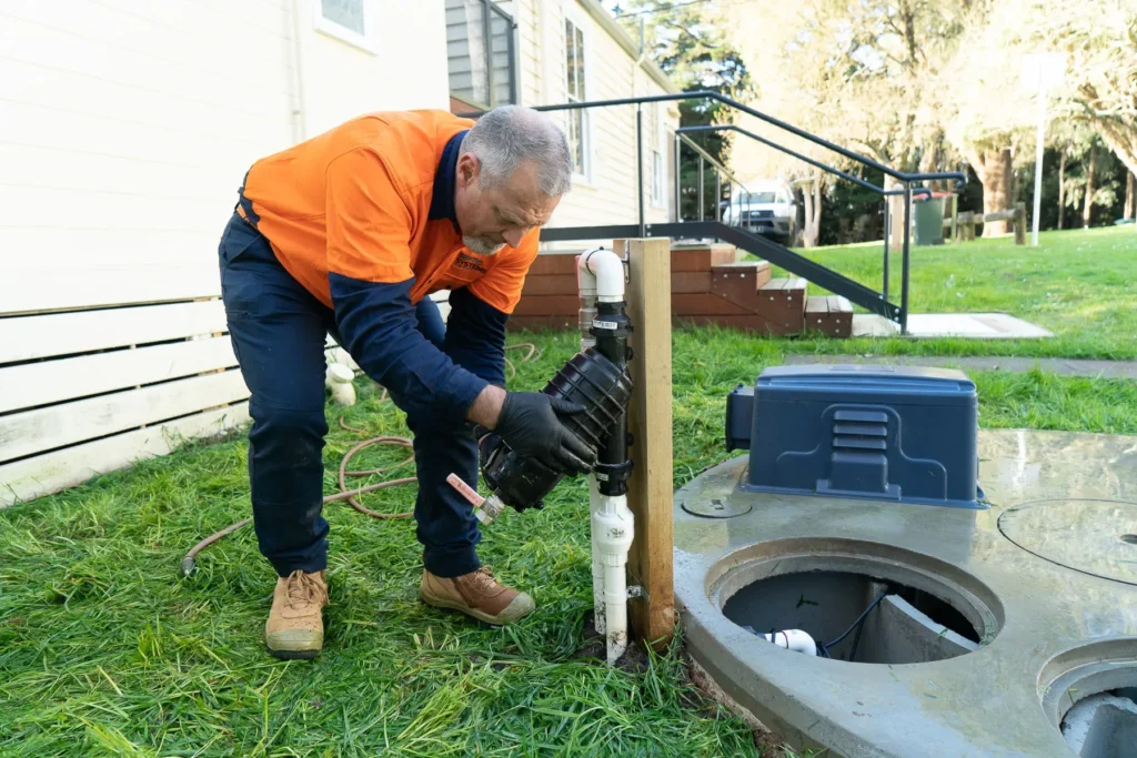 Septic technician servicing a residential septic tank and control box