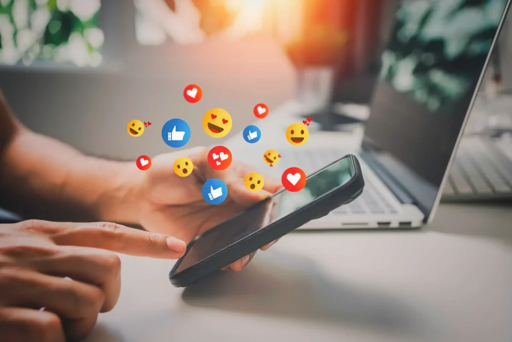 Phone and laptop with social media engagement icons floating above