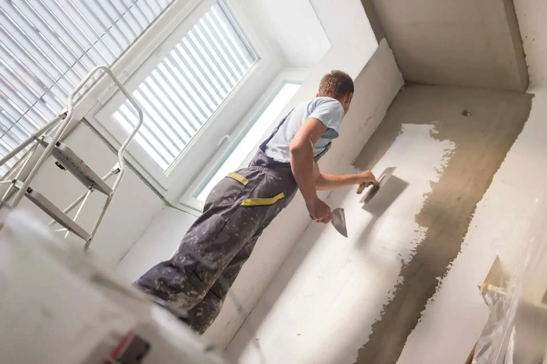 Plasterer smoothing an interior stucco wall finish