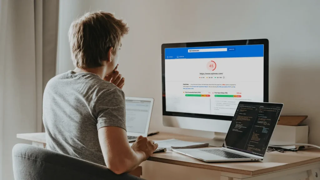 Developer reviewing website performance metrics on desktop monitors