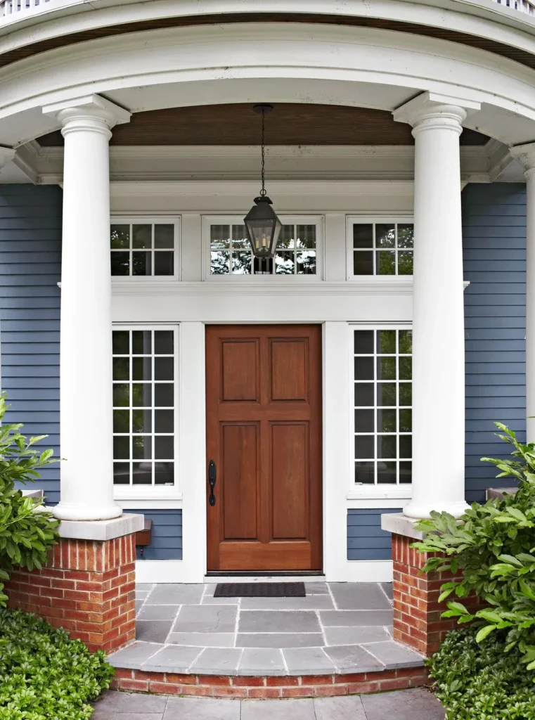Home entrance with a new front door framed by white columns